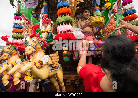 I devoti che offrono ciotole di frutta per le divinità durante il carro Tamil Festival, un annuale pubblica indù processione in West Ealing, Londra Foto Stock