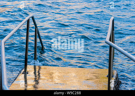 I passi nel contenitore di nuoto in un freddo, ventoso inverno mattina presso la baia di prezzemolo, NSW, Australia in agosto 2019 Foto Stock