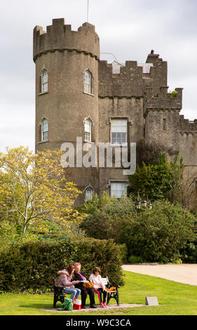 In Irlanda, il Leinster, Fingal, Co Dublin, il Castello di Malahide, i visitatori si sedette sul prato da banco Foto Stock