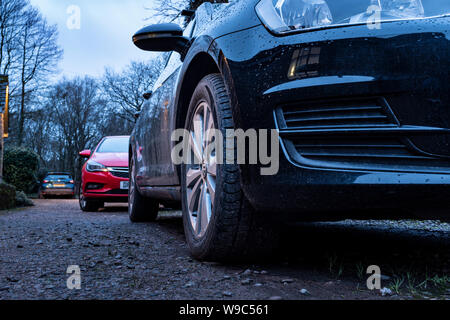 Auto parcheggiata su un viale di accesso al di fuori di una casa al crepuscolo. Foto Stock