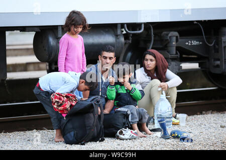 Dugo Selo, Croazia - 17 Settembre 2015 : una famiglia siriana seduti sui binari del treno dopo che arrivano dalla Serbia e in attesa per il bus per continuare Foto Stock