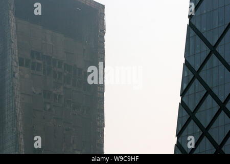 Il danneggiato il Mandarin Oriental Hotel edificio è visto vicino la nuova torre di TVCC a Pechino in Cina, Martedì, 10 febbraio 2009. Un hotel Edificio in co Foto Stock