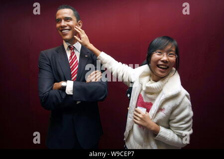 Un visitatore cinese si sente una cera figura di U.S. Il presidente Barack Obama al museo delle cere di Madame Tussauds a Shanghai in Cina, 16 novembre 2009. Un incre Foto Stock