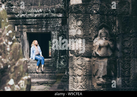 Caucasian donna bionda scoprendo le rovine di Angkor Wat tempio complesso in Siem Reap, Cambogia. Foto Stock