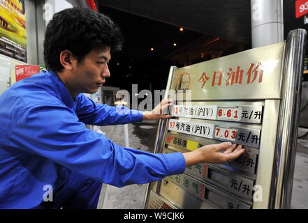 Un lavoratore cinese aggiorna i prezzi del carburante in corrispondenza di una stazione di rifornimento di Sinopec in Cina a Shanghai, 10 novembre 2009. La Cina, i mondi secondo più grande utente di energia, Foto Stock