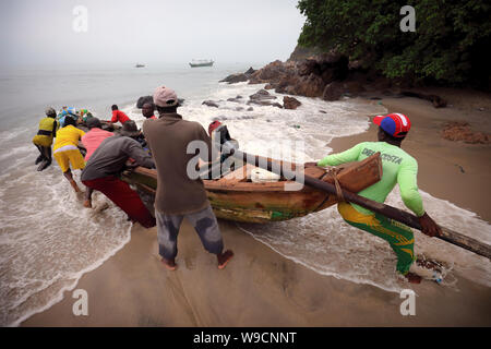 Fisher lanciare una barca in Senya Beraku, Ghana. La pesca illegale delle navi straniere minaccia tradizionali villaggi di pescatori in Ghana Foto Stock