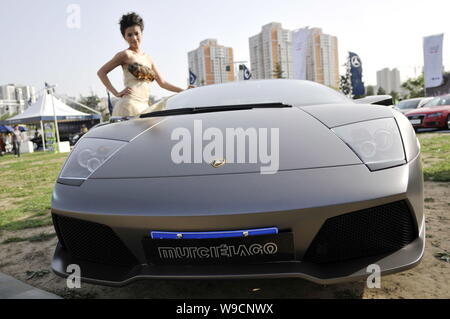 --FILE -- un modello pone accanto a una Lamborghini Murcielago sullo schermo durante un auto show di Pechino, Cina, 20 giugno 2009. La Cina diventerà uno dei luxu Foto Stock