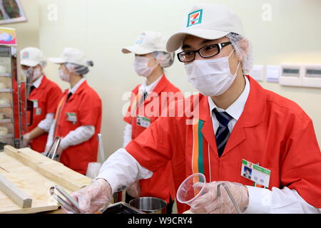 I dipendenti cinesi sono visto che serve i clienti a 7-Eleven convenienza chain store in Cina a Shanghai, giovedì, 30 aprile 2009. 7-Eleven giovedì (3 Foto Stock