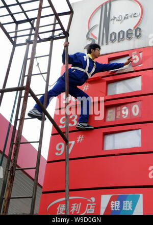 Un lavoratore cinese aggiorna i prezzi del carburante in corrispondenza di una stazione di rifornimento di Sinopec in Yichang city, porcellane centrale provincia di Hubei, Mercoledì, 30 settembre 2009. Cina Foto Stock