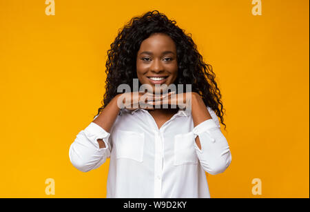 Giovane donna afro poggiando il mento sulle mani Foto Stock