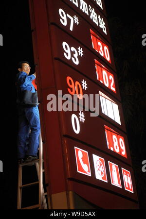 Un cinese alla stazione di servizio lavoratore aggiorna i prezzi del carburante in corrispondenza di una stazione di rifornimento di Sinopec nella città di Xiamen, sudest Chinas provincia del Fujian, Venerdì, 19 Dicembre Foto Stock