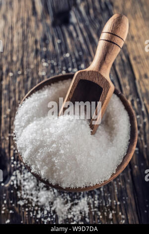 A GRANA GROSSA sale in una ciotola di legno con un mestolo su un vecchio tavolo in legno di quercia Foto Stock