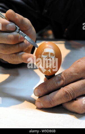 Folk Cinese scultore Kang Yongguo scolpisce il ritratto di U.S. Il presidente Barack Obama il guscio di un uovo di gallina nel suo studio di Shenyang city, n. Foto Stock