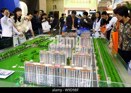 --FILE--visitatori cinesi guardare al modello appartamento residenziale edifici e ascoltare a casa gli agenti durante una fiera hosue a Pechino, in Cina, il 18 maggio 2008. Foto Stock