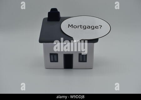 Un modello di casa con la parola 'Mortgage?" in un discorso bolla sul tetto. Foto Stock