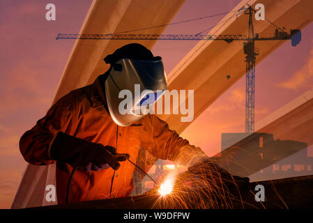 La doppia esposizione del lavoratore di saldatura struttura in acciaio con gru industriali e urban expressway. concetto di foto per lâ industria delle costruzioni e ingegneria Foto Stock