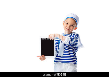 Vista frontale di sorridere preschooler bambino in costume da marinaio holding tavoletta digitale con schermo vuoto isolato su bianco Foto Stock