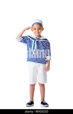 Lunghezza piena vista del sorridente preschooler bambino in costume da marinaio salutando e cercando in telecamera isolato su bianco Foto Stock