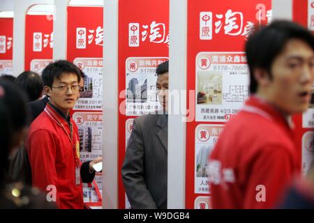 --FILE--cinese di agenti immobiliari, in rosso, introdurre di seconda mano case per i visitatori a una fiera della casa in Cina a Shanghai, 13 aprile 2008. Proprietà pri Foto Stock