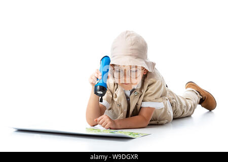 Focalizzato explorer bambino nel cappello e occhiali azienda torcia e guardando la mappa su bianco Foto Stock