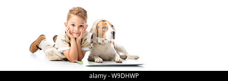 Panoramica di sorridere esplorare boy e cane beagle in hat vicino a mappa su bianco Foto Stock