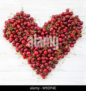 Fresche ciliege dolci a forma di cuore, vista aerea. Appartamento laico, vista dall'alto. Foto Stock