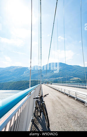 Tema della mountain bike in Scandinavia. turistico umana in casco e abbigliamento sportivo in bicicletta in Norvegia su Hardanger sospensione ponte ponte gettato Foto Stock