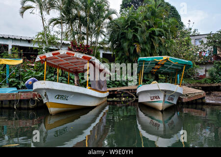 Acqua colorata taxi chiamato Pangas legato fino al dock lungo la laguna Sontecomapan in Sontecomapan, Veracruz, Messico. La laguna che sfocia nel golfo del Messico è uno dei meglio conservati delle zone umide costiere e foreste di mangrovie in Messico e in parte di Los Tuxtlas riserva della biosfera. Foto Stock