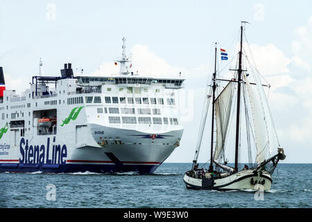 Barca a vela e Stena Line traghetto in avvicinamento al porto, Rostock Germania Foto Stock