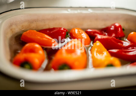 Peperoni colorati in acqua in smalto vintage ciotola. Close up Foto Stock