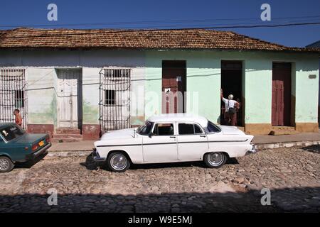 TRINIDAD, CUBA - Febbraio 5, 2011: la gente a piedi da oldtimer americano "yank cisterna " auto in Trinidad. Cuba ha uno dei più bassi auto pro-capite le tariffe (38 p Foto Stock