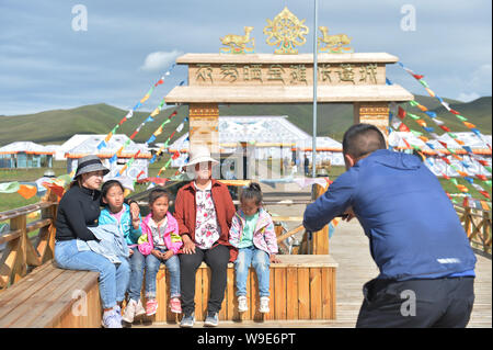 (190813) -- GANNAN, Agosto 13, 2019 (Xinhua) -- i turisti posano per una foto a una tenda scenic spot Gaxiu nel villaggio di Gahai Township, Luqu County, Gannan tibetano prefettura autonoma, a nord-ovest della Cina di Provincia di Gansu, Agosto 13, 2019. In questi ultimi anni, Gannan promossa la cultura e industria del turismo per incrementare il reddito delle popolazioni locali. (Xinhua/Wang Huajuan) Foto Stock