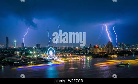 Tempesta tuono fulmine su il cielo nuvoloso scuro su business area building a Bangkok, Tailandia. Foto Stock