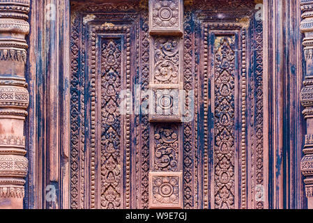 Porta cieca, balaustre scavate nella pietra arenaria rossa pareti di Banteay Srei area del tempio di Angkor a Siem Reap, Cambogia Foto Stock