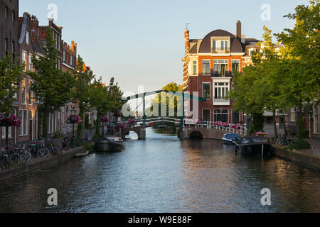 Leiden, Olanda - Giugno 26, 2019: Appartamenti e case a kerkgracht Hooglandse vicino a Oude Rijn canal al tramonto Foto Stock