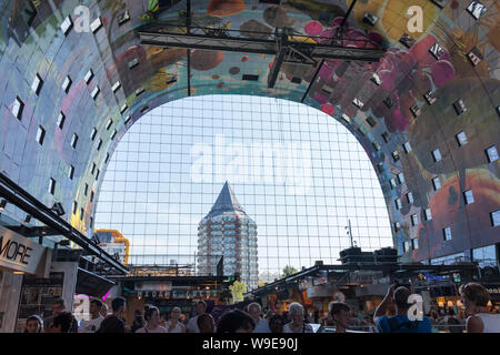 Rotterdam, Olanda - Luglio 30, 2019: illustrazione in corrispondenza della parete del Markthal e una vista alla matita edificio attraverso le finestre di vetro Foto Stock