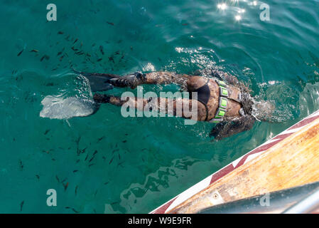 Creta, Grecia. Vista posteriore di un subacqueo snorkeling, esplorando il mare di Creta appena al largo di Chania, occidentale di Creta Foto Stock