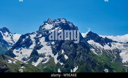 Picco di montagna in nero, ricoperta di ghiacciai e nevi. Dombay, Caucaso del Nord, Russia Foto Stock