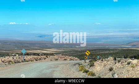 Strada vuota, scenic curva autostrada con giallo cartello stradale ruotare la freccia nel deserto di Atacama, Cile Foto Stock