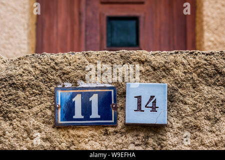 Numero di casa le piastre sulla parete roughcast Foto Stock