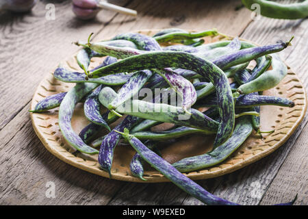 Materie organiche rattlesnake homegrown fagioli, cimelio di verdure nella piastra in ceramica, impianto basato cibo, vicino il fuoco selettivo Foto Stock