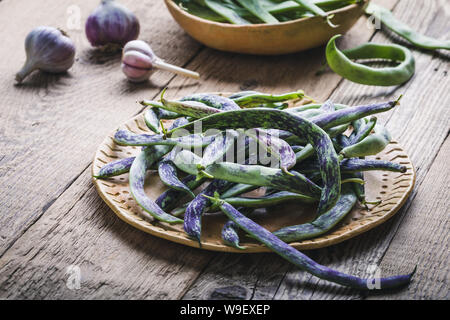 Materie organiche rattlesnake homegrown fagioli, cimelio di verdure nella piastra in ceramica, impianto basato cibo, vicino il fuoco selettivo Foto Stock