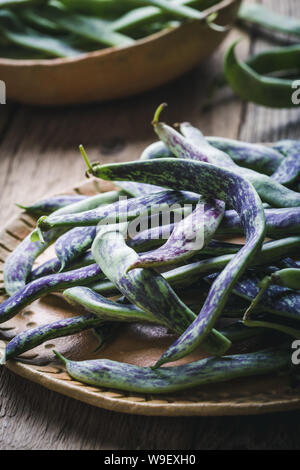 Materie organiche rattlesnake homegrown fagioli, cimelio di verdure nella piastra in ceramica, impianto basato cibo, vicino il fuoco selettivo Foto Stock