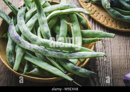 Materie organiche rattlesnake homegrown fagioli, cimelio di verdure nella piastra in ceramica, impianto basato cibo, vicino il fuoco selettivo Foto Stock