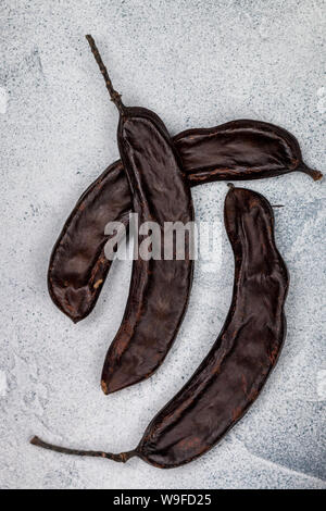 La carruba. Una sana organico cialde dolci con semi. Mangiare sano. Messa a fuoco selettiva, vista dall'alto Foto Stock