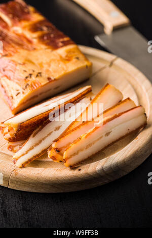 Carne affumicata. Saporita pancetta sul tagliere. Foto Stock