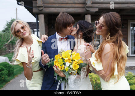 Groomsmen e damigelle con appena sposati sulla cerimonia di nozze Foto Stock