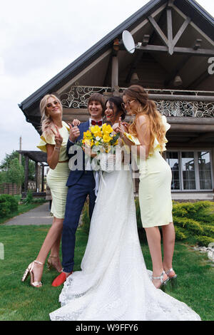 Groomsmen e damigelle con appena sposati sulla cerimonia di nozze Foto Stock