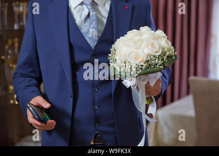 Mattina Groom Wedding Tasse . elegante elegante felice lo sposo con bouquet . Elegante fiducioso giovane e bella sposa con bouquet di nozze in mani Foto Stock