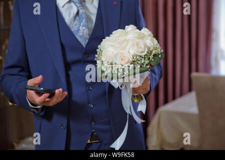 Mattina Groom Wedding Tasse . elegante elegante felice lo sposo con bouquet . Elegante fiducioso giovane e bella sposa con bouquet di nozze in mani Foto Stock